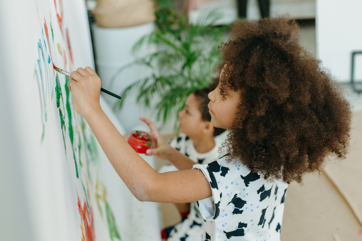 A Child With Printed Top Painting on a Wall